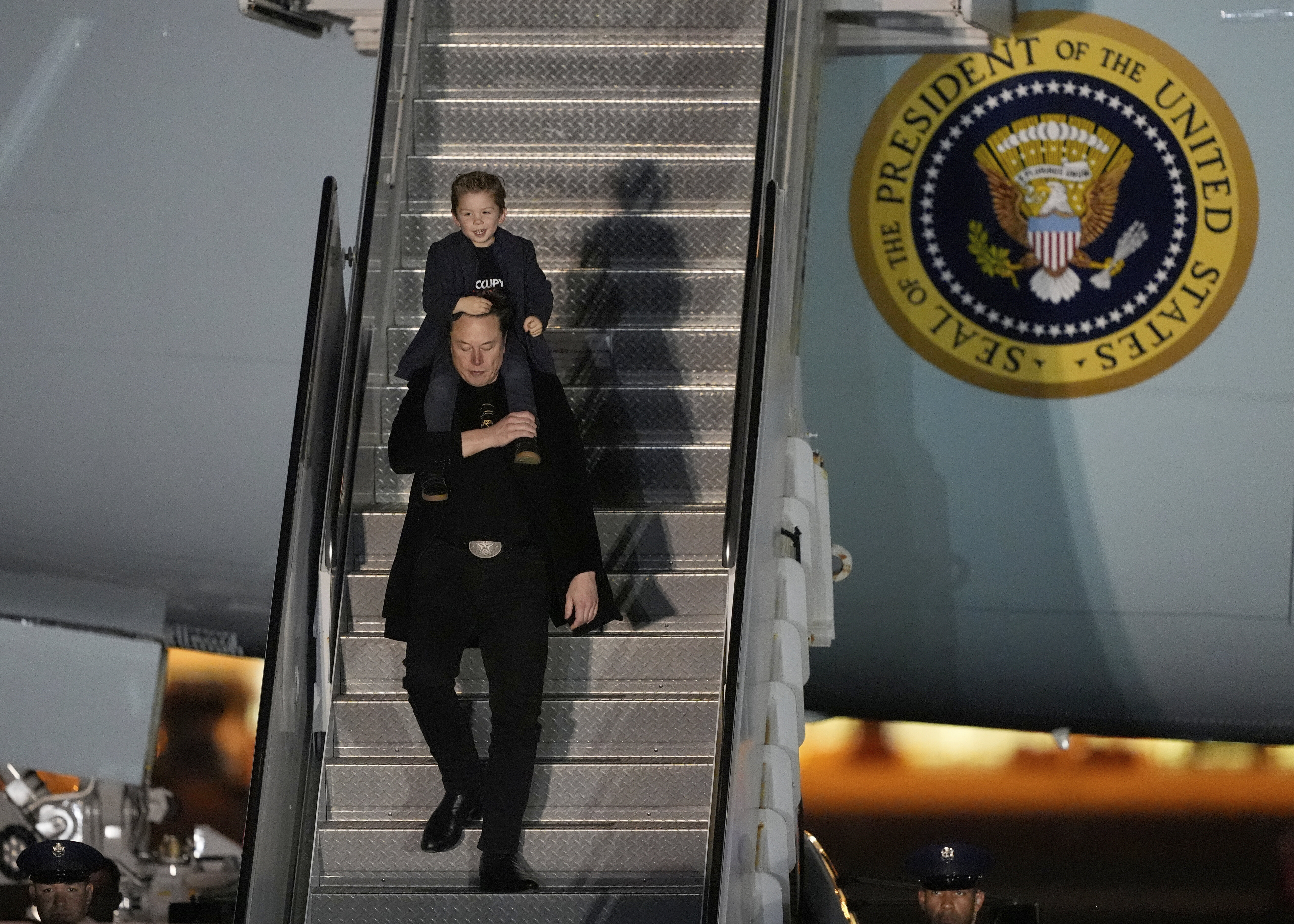Elon Musk carries his son X Æ A-Xii as they arrive on Air Force One with President Donald Trump, not pictured, at Miami International Airport, April 12, 2025.