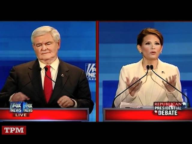 Two political figures at debate podiums with microphones on a split-screen broadcast.