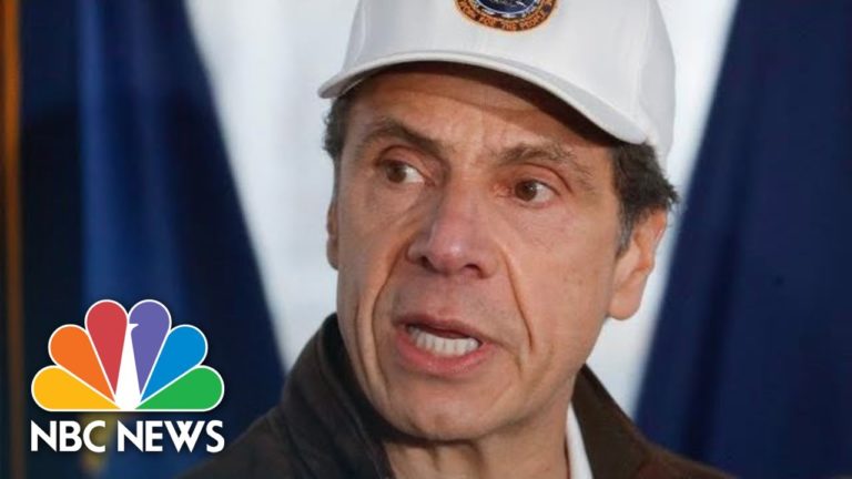 Man in white baseball cap speaking with a blue and white background and NBC News logo overlay