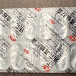 Foil blister pack containing multiple white pills, printed with non-English characters.