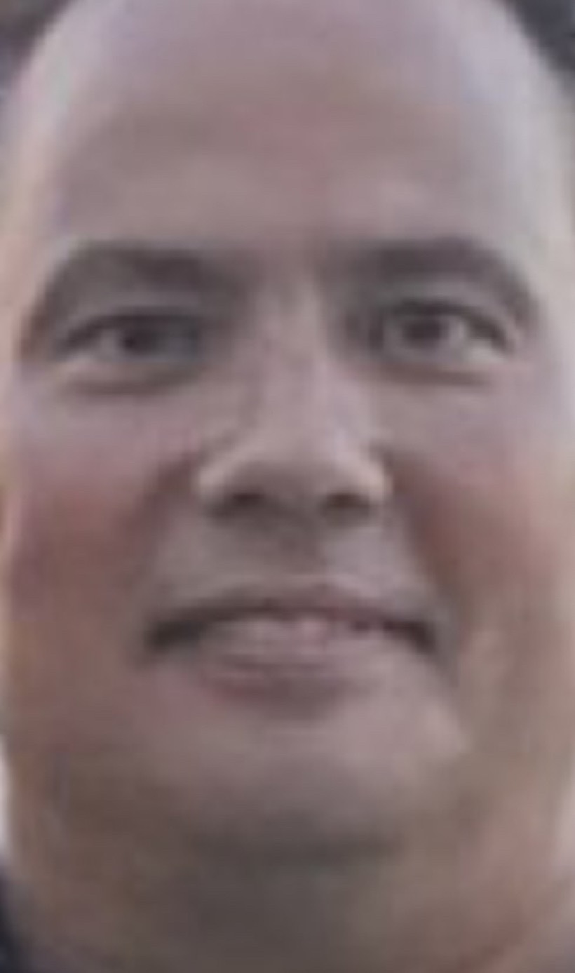 Close-up of a person’s face with short hair, looking toward the camera.