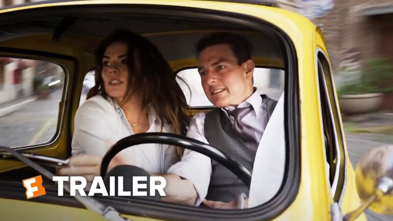 Two actors in a yellow car, one driving, the other in the passenger seat