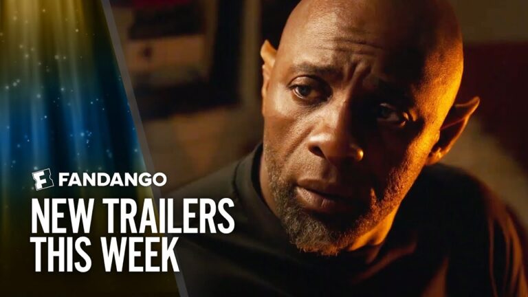 Close-up of a bald man with a beard beside Fandango logo and “New Trailers This Week” text.