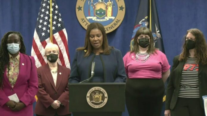 Woman at a podium with four masked officials standing behind against U.S. flags