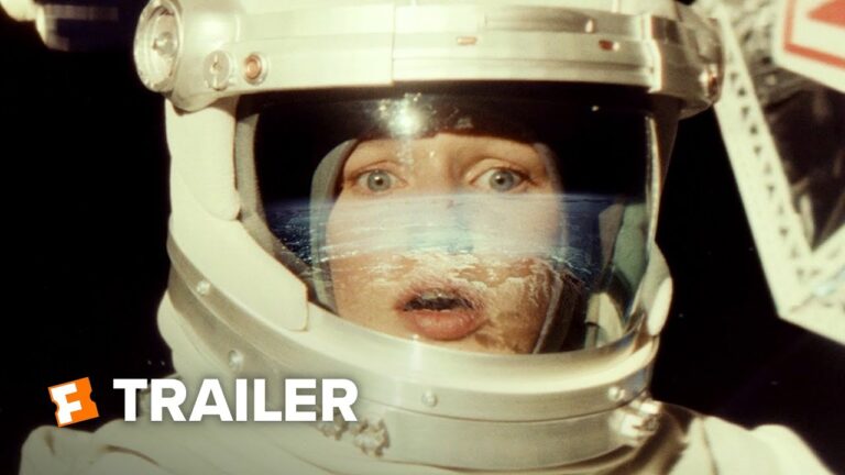 Man’s face visible through space helmet visor with trailer-style graphic text.