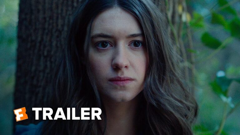 Woman with long dark hair looks ahead in an outdoor setting.