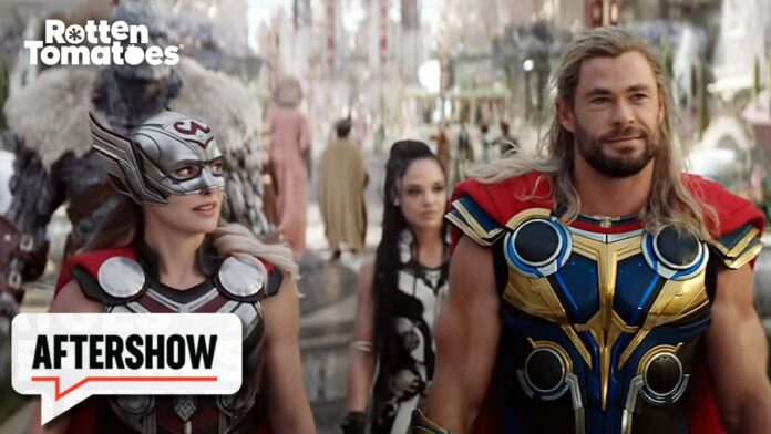 Two people in Thor costumes on a crowded street; Rotten Tomatoes and Aftershow branding.