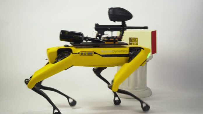 Yellow four-legged robotic device with camera and sensors mounted at front