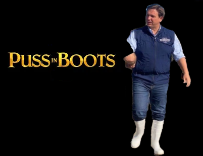 A man stands in front of a “Puss in Boots” text backdrop with stage lighting.
