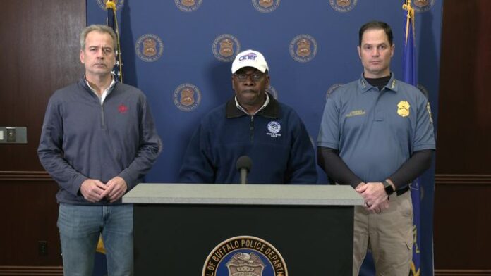 Three people stand behind a podium with the Buffalo Police Department seal in front of a blue backdrop.
