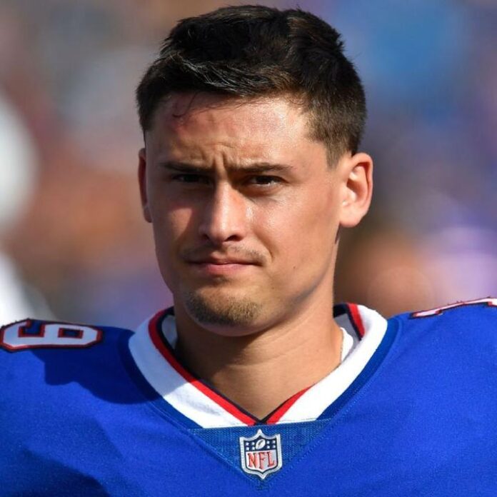 Male athlete wearing a blue football jersey with a visible NFL logo badge.
