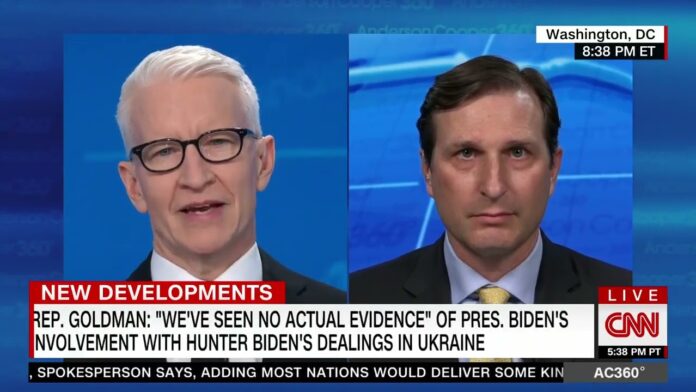 Two men appear in a split-screen news segment on a blue background.