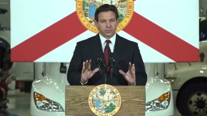 Speaker at a podium with two microphones, wearing a suit and tie.