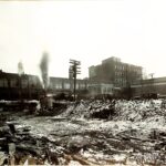 Wintry outdoor industrial yard with smoke stacks, steam, and buildings
