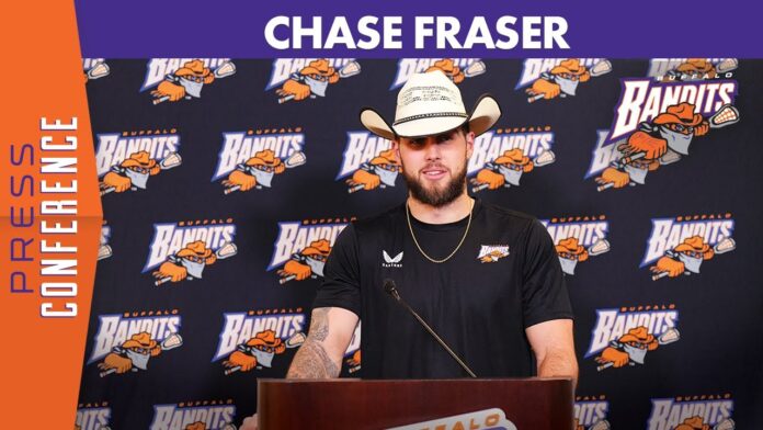 Man in cowboy hat at a podium in front of Buffalo Bandits step-and-repeat backdrop