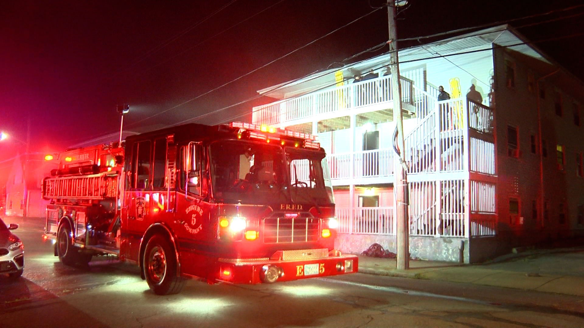 A fire truck parked outside a three story building