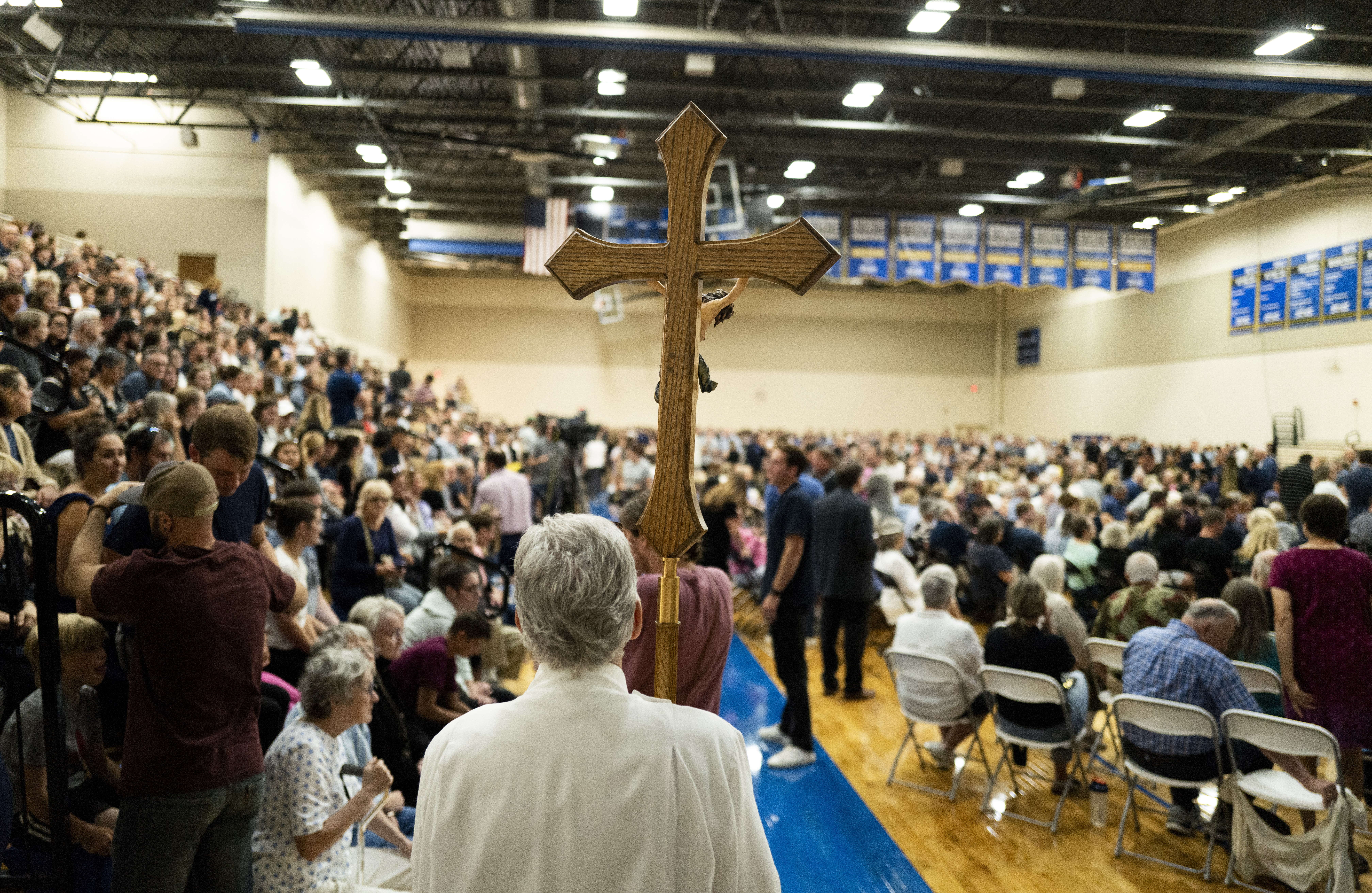 Man holds up cross at vigil for Annunciation Catholic School vigil