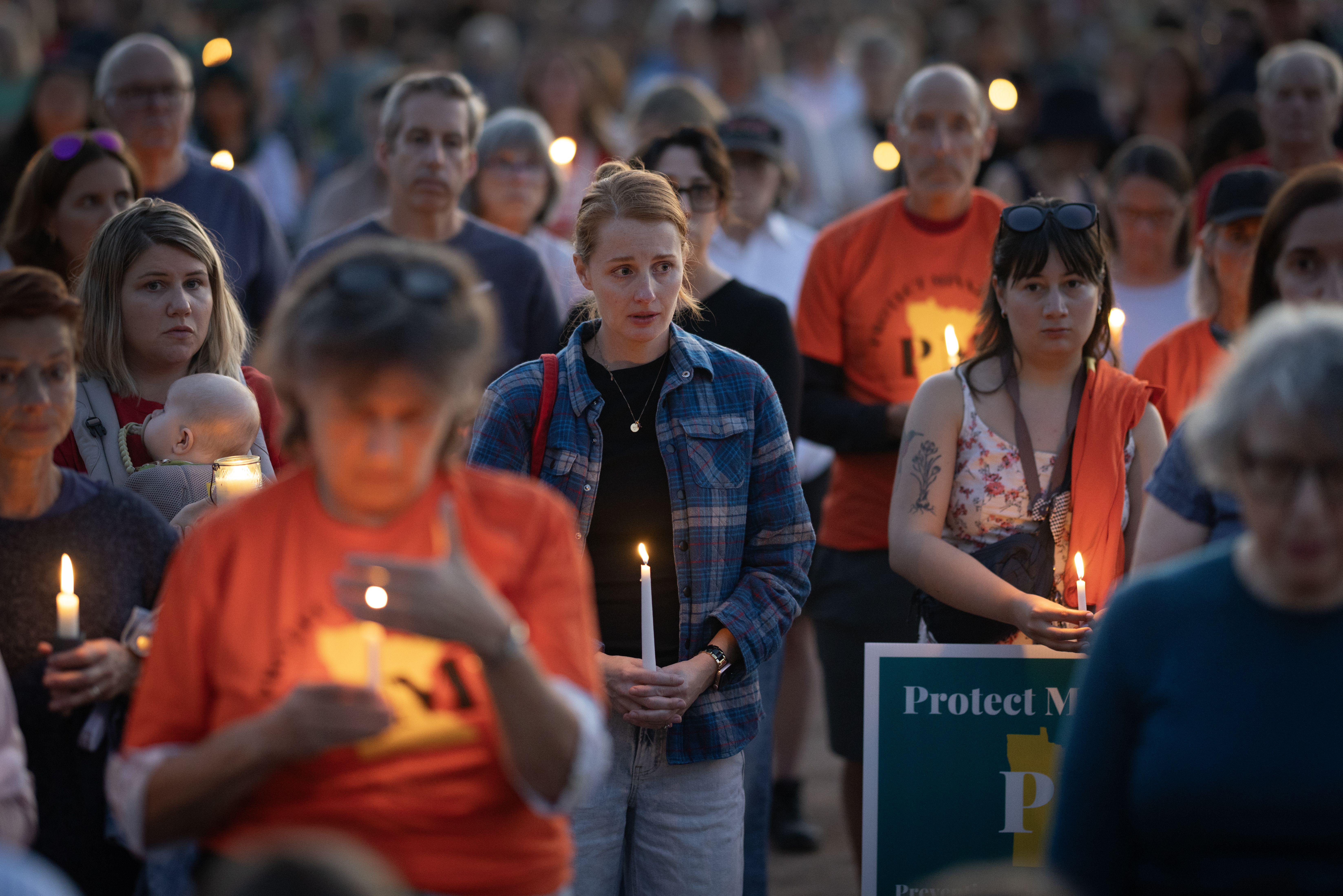 People hold candles at a vigil for Annunciation Catholic School shooting victims